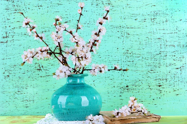 Beautiful blooming branches in vase on blue background — Stock Photo, Image