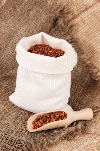 Grains in sack on wooden background — Stock Photo, Image