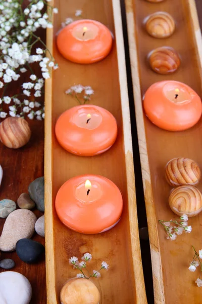 Krásné svíčky ve vodě na dřevěný stůl detail — Stock fotografie