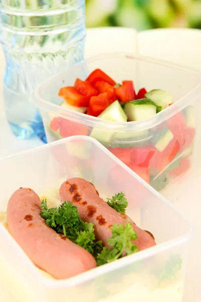 Smakelijke lunch in plastic verpakkingen, op houten achtergrond — Stockfoto