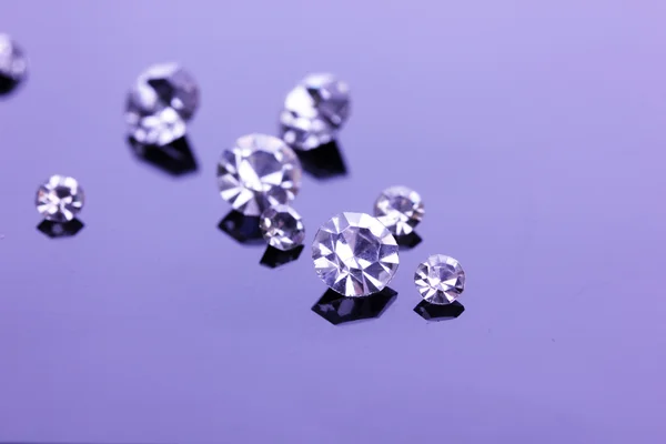 Beautiful shining crystals (diamonds), on purple background — Stock Photo, Image