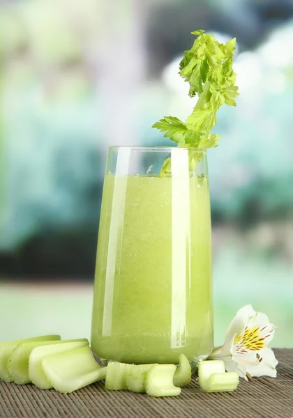 Ποτήρι χυμό σέλινο, σε χαλί μπαμπού, σε πράσινο φόντο — Φωτογραφία Αρχείου