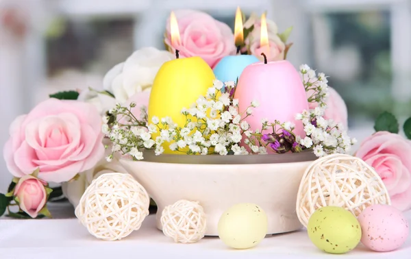 Pasen kaarsen met bloemen op achtergrond van venster — Stockfoto