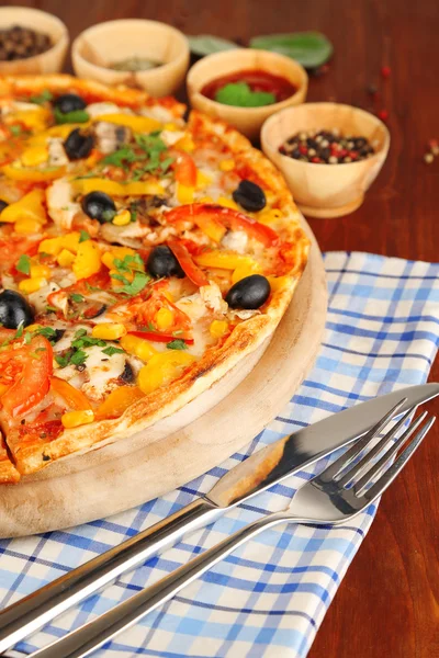 Smakelijke pizza met keuken kruiden op houten tafel close-up — Stockfoto