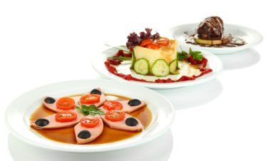 küçük porsiyonlarda yemek büyük beyaz plakaları üzerinde beyaz izole