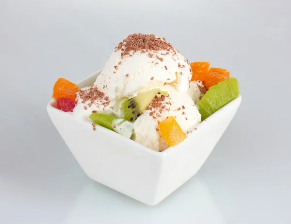 Delicioso helado de vainilla con chocolate y fruta en un tazón aislado en blanco —  Fotos de Stock