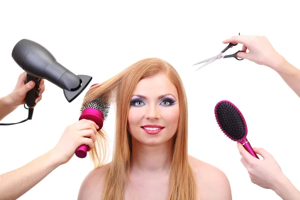 Mulher bonita e mãos com escovas, tesoura e secador de cabelo isolado no branco — Fotografia de Stock