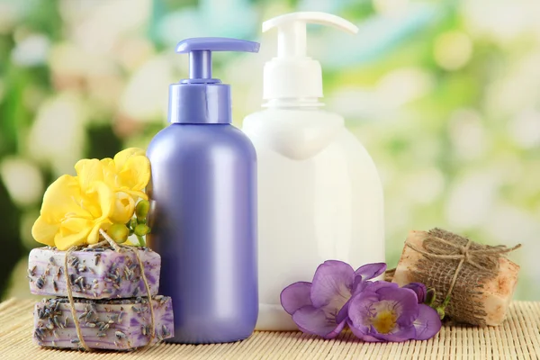 Liquid and hand-made soaps on wooden table, on green background — Stock Photo, Image