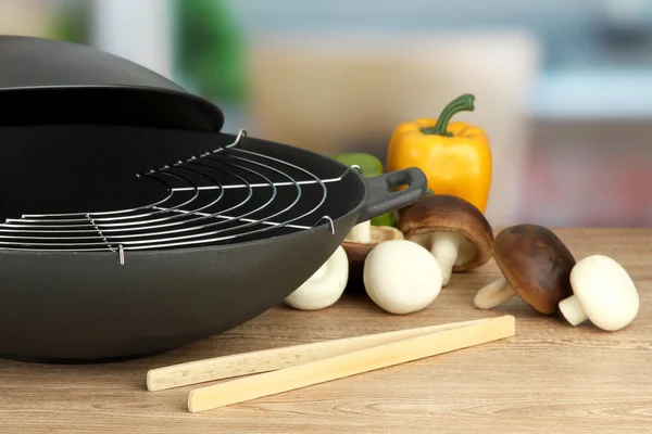 Padella wok nero e verdure sul tavolo della cucina, da vicino — Foto Stock