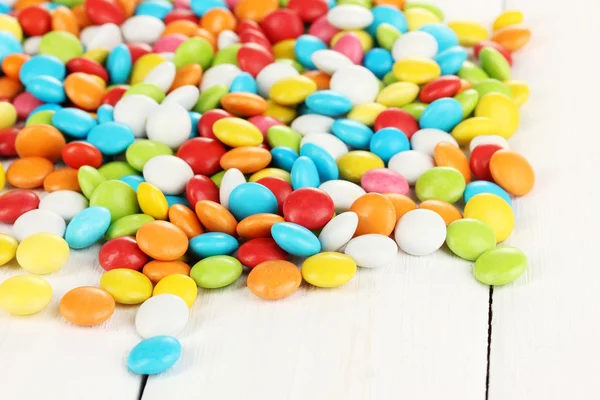 Coloridos caramelos sobre fondo de madera blanca — Foto de Stock