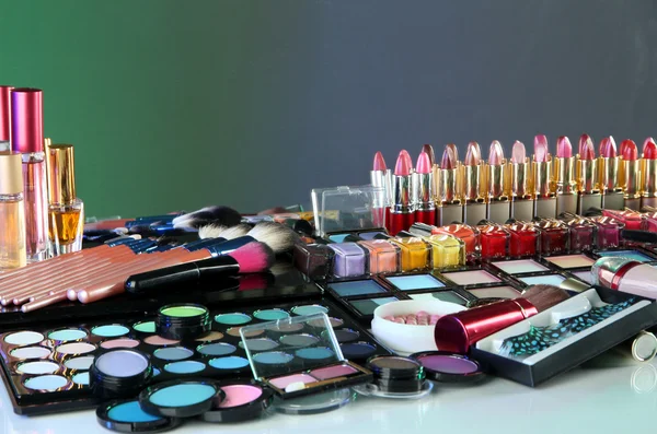 Wiele różnych kosmetyków na zielonym tle — Zdjęcie stockowe