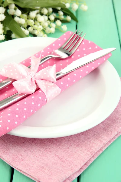 Tischdekoration in weißen und rosa Tönen auf farbigem Holzhintergrund — Stockfoto