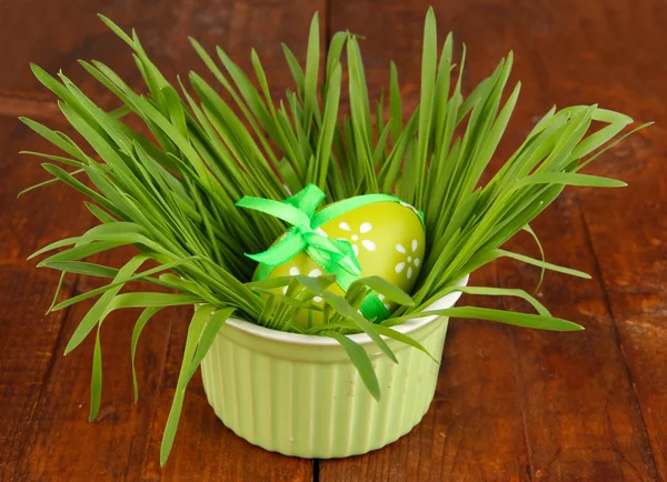Uova di Pasqua in ciotola con erba sul tavolo di legno da vicino — Foto Stock