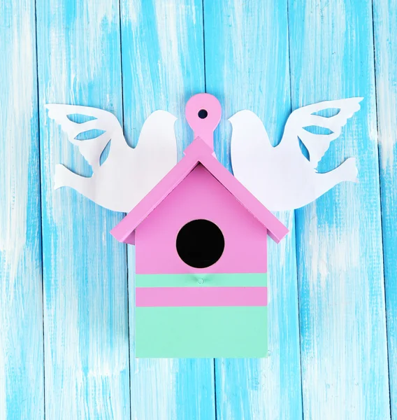 Caixa de nidificação decorativa com pássaros de papel, na cor de fundo de madeira — Fotografia de Stock