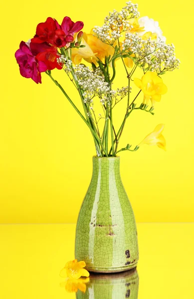 Beautiful bouquet of freesia in vase on yellow background — Stock Photo, Image