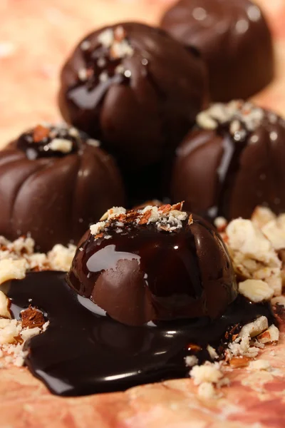 Caramelle al cioccolato con noci, su sfondo colore — Foto Stock