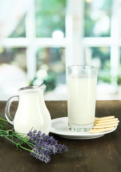 Copo de leite, um jarro e biscoitos em um contexto de quarto — Fotografia de Stock