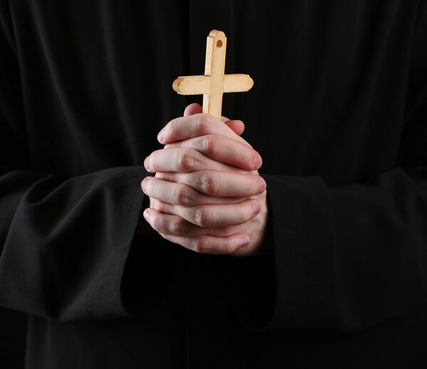 Priest holding cross, close up
