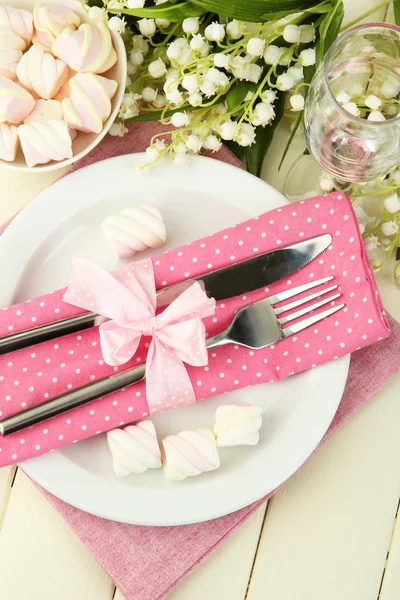 Table setting in white and pink tones on color wooden background Rechtenvrije Stockfoto's