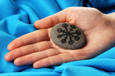 servet taş kumaş mavi zemin üzerine el sembollerle anlatmaya