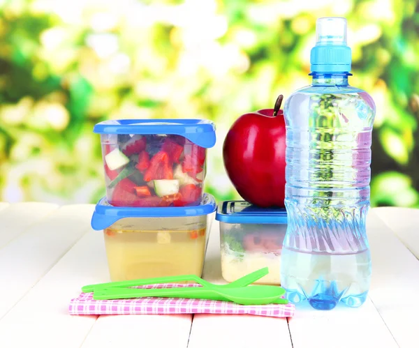 Smakelijke lunch in plastic verpakkingen, op houten tafel op lichte achtergrond — Stockfoto