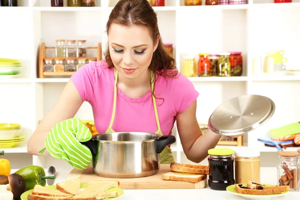 Young woman cooking in kitchen — Stock Photo, Image