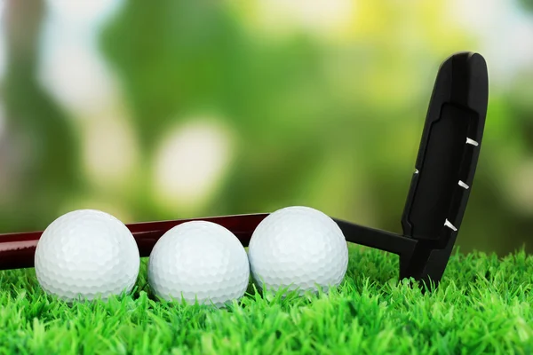 Pelotas de golf y conductor en césped verde al aire libre de cerca —  Fotos de Stock