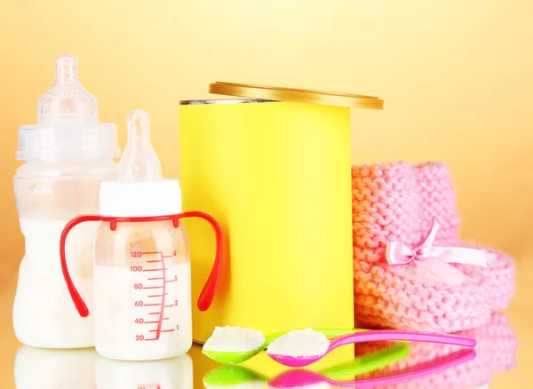 Botellas con leche y alimentos para bebés sobre fondo beige — Foto de Stock