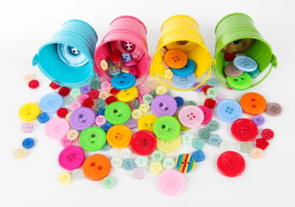Colorful buttons strewn from buckets isolated on white — Stock Photo, Image