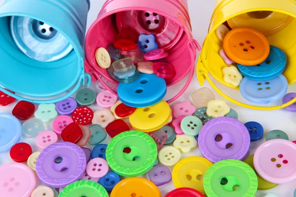 Colorful buttons strewn from buckets close-up — Stok fotoğraf