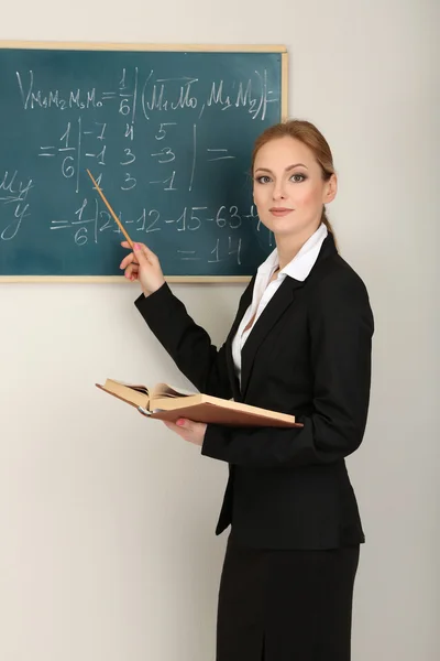 Portrait of teacher woman near the chalkboard in classroom — Stock Photo, Image