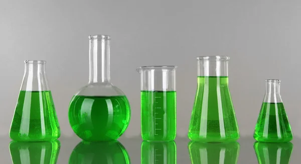 Test-tubes with green liquid on gray background — Stock Photo, Image