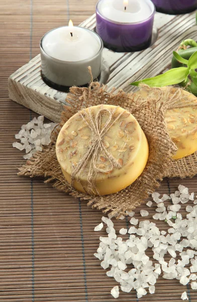 Ručně vyráběné mýdlo a mořská sůl na šedé bambusové rohože — Stock fotografie