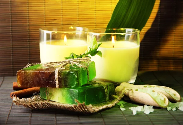 Hand made soap and candles on bamboo mat background — Stock Photo, Image