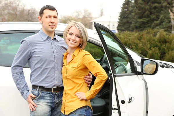 Retrato de feliz casal bonito de pé perto do carro — Fotografia de Stock