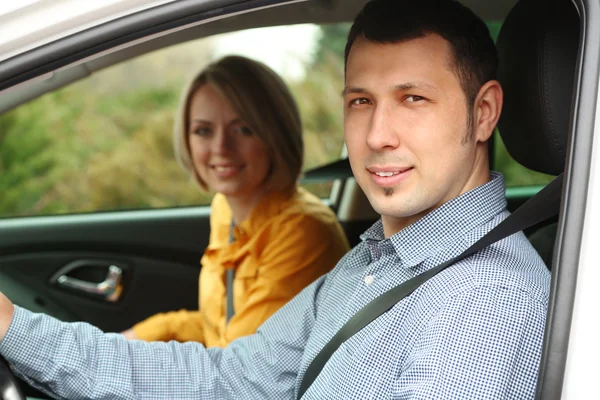 Portrait de jeune beau couple assis dans la voiture — Photo