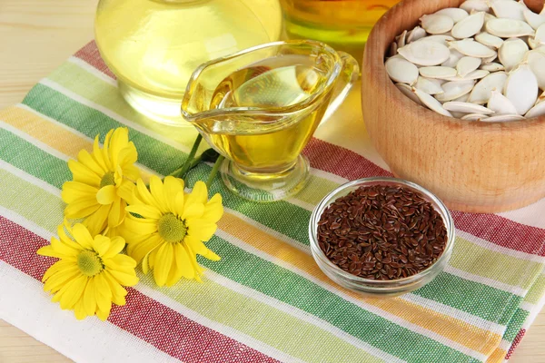 Nützliches Leinöl und Kürbiskernöl auf Holztisch in Großaufnahme — Stockfoto