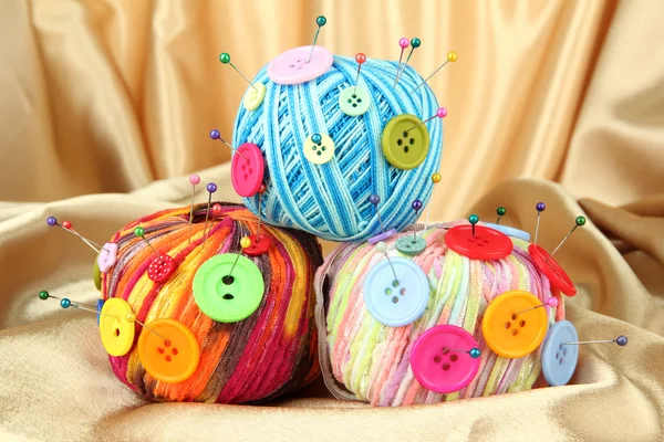 Colorful buttons and multicolor wool balls, on color fabric background — Stock Photo, Image