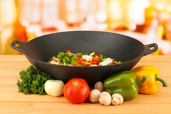 Wok con ragú vegetal sobre mesa de madera, sobre fondo brillante — Foto de Stock