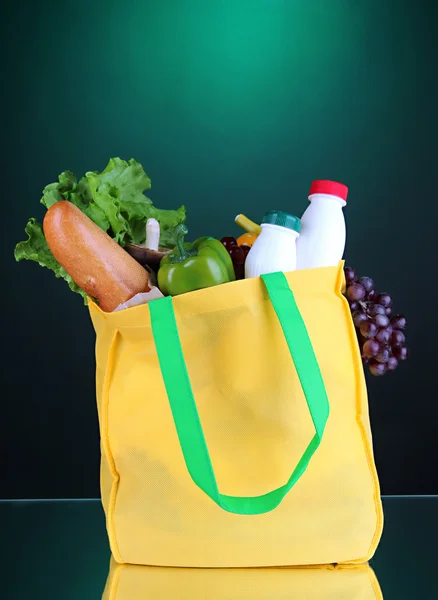 Öko-Tasche mit Einkauf auf dunkelgrünem Hintergrund — Stockfoto