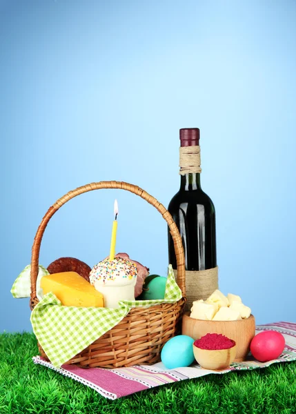 Easter basket: Conceptual photo of traditional easter food in wicker basket, on green grass, on color background — Stock Image Easter basket: Conceptual photo of traditional easter food in wicker basket, on green grass, on color background Stock Photo