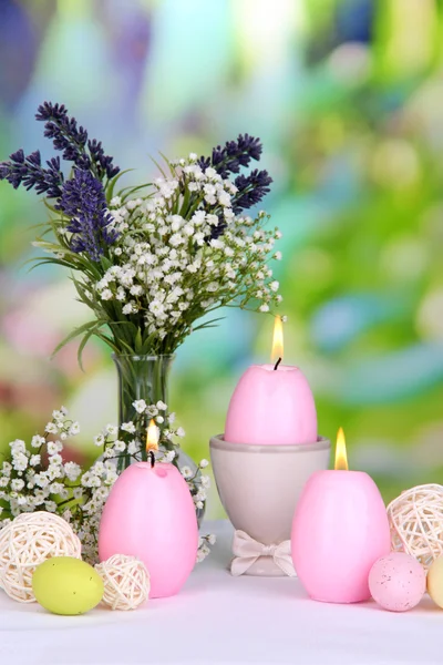 Påsk ljus med blommor på ljus bakgrund — Stockfoto