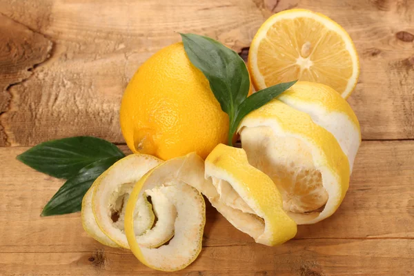 Limones maduros con hojas sobre mesa de madera —  Fotos de Stock