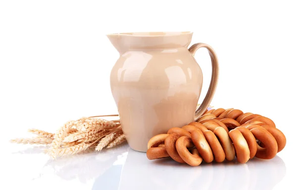 Vaso di latte, gustosi bagel e spighette, isolato su bianco — Foto Stock