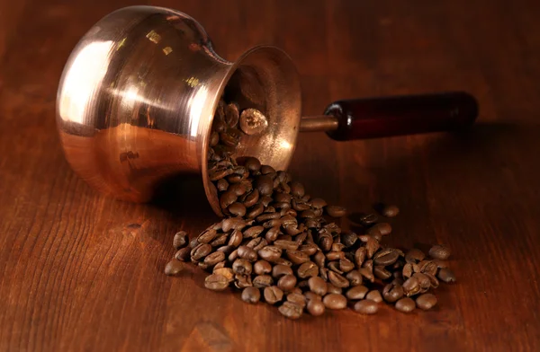 Cafetera con granos de café sobre fondo de madera marrón — Foto de Stock