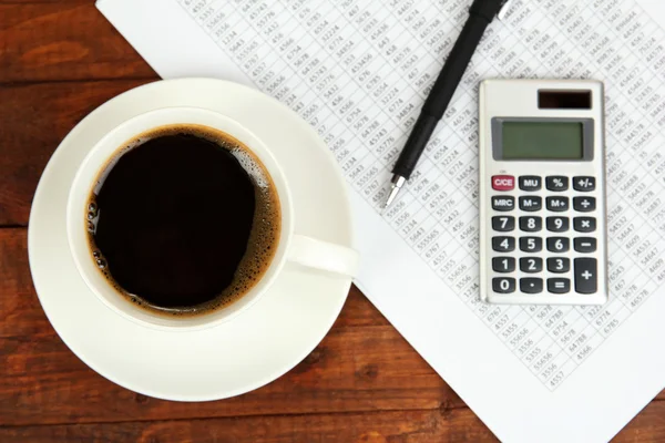 Taza de café en la mesa de trabajo cubierta con documentos de cerca — Foto de Stock