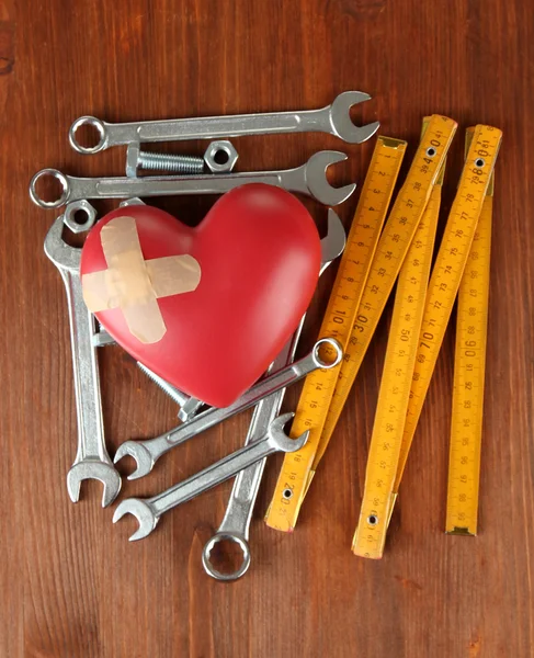 Heart and tools. Concept: Renovation of heart. On wooden background — Stock Photo, Image