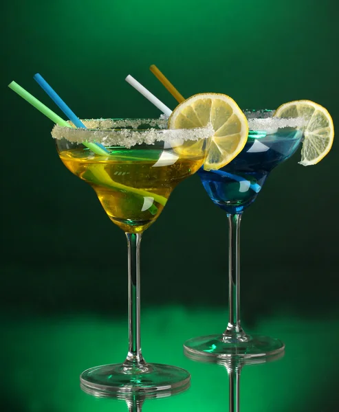Yellow and blue cocktails in glasses on color background — Stock Photo, Image