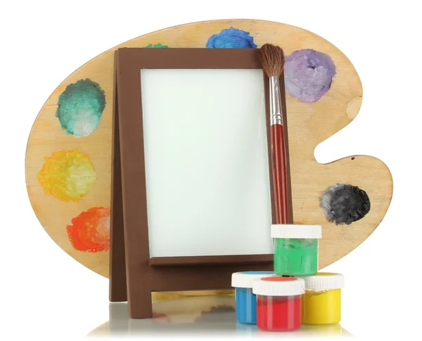 Photo frame as easel with artist's tools isolated on white — Stock Photo, Image