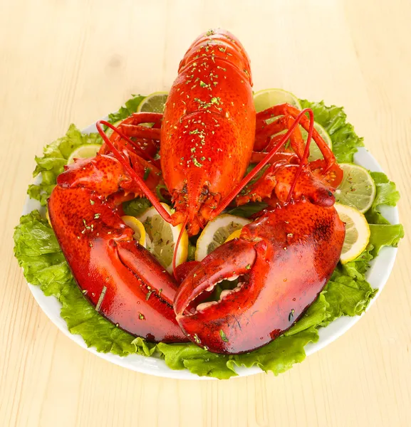 Red lobster on platter with vegetables on wooden table close-up — Stock Photo, Image